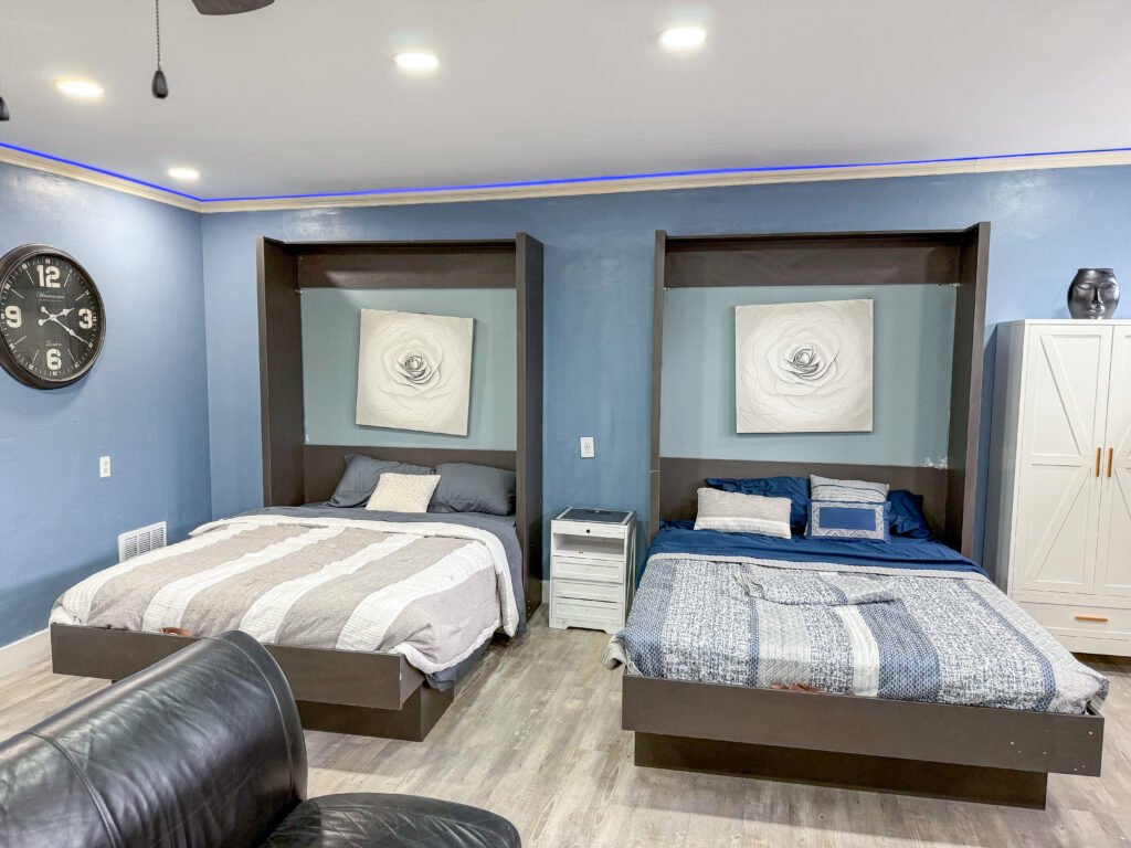 Sleeping area inside Unit 1 at The Flight Deck Residences with two beds and blue accent lighting.