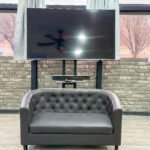 Lounge area with seating and wall-mounted television inside Unit 1 at The Flight Deck Residences.