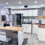 Kitchen with center island and bar seating inside Unit 1 at The Flight Deck Residences.