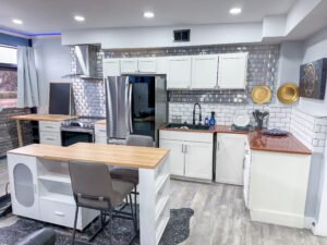 Kitchen with center island and bar seating inside Unit 1 at The Flight Deck Residences.
