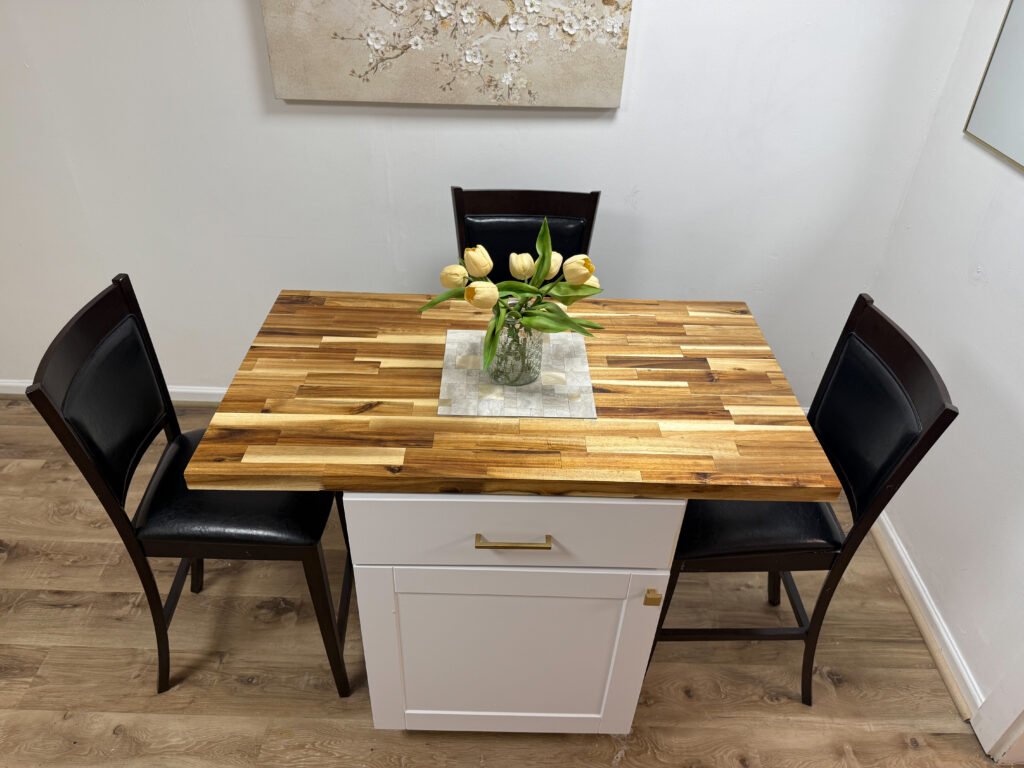 Dining area with butcher block table and seating inside Unit 2 at The Flight Deck Residences.