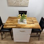 Dining area with butcher block table and seating inside Unit 2 at The Flight Deck Residences.