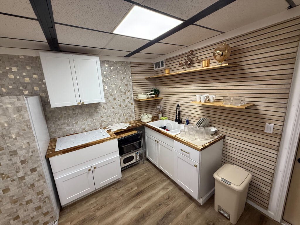Kitchen with white cabinets and open shelving inside Unit 2 at The Flight Deck Residences.
