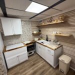 Kitchen with white cabinets and open shelving inside Unit 2 at The Flight Deck Residences.