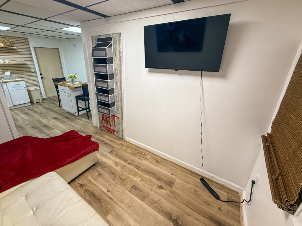 Living area with wall-mounted television inside Unit 2 at The Flight Deck Residences.