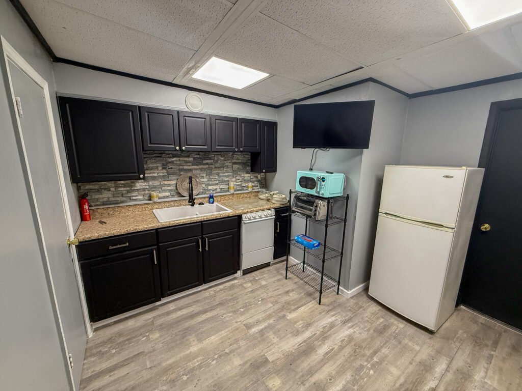 Kitchen with dark cabinets and butcher block counter inside Unit 3 at The Flight Deck Residences.