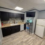Kitchen with dark cabinets and butcher block counter inside Unit 3 at The Flight Deck Residences.