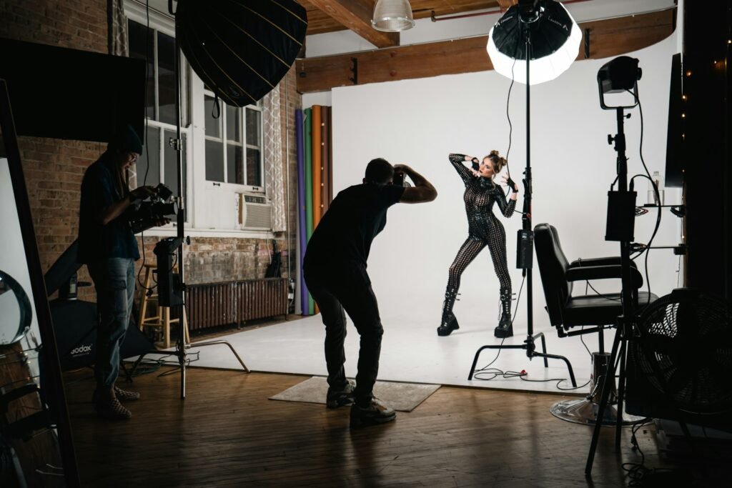 Photographers working with a subject under studio lighting